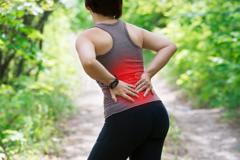 Woman with back pain, kidney inflammation, injury during workout, outdoors concept. Woman with back pain, kidney inflammation, injury during workout, outdoors concept