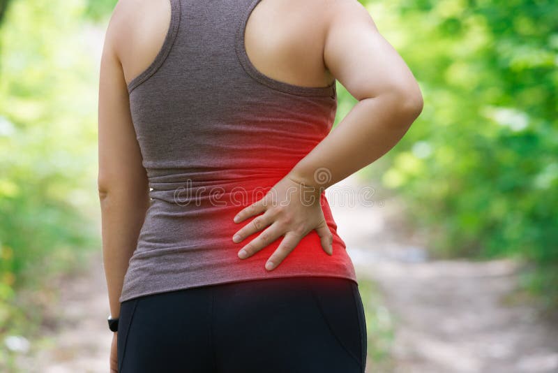 Woman with back pain, kidney inflammation, injury during workout, outdoors concept. Woman with back pain, kidney inflammation, injury during workout, outdoors concept