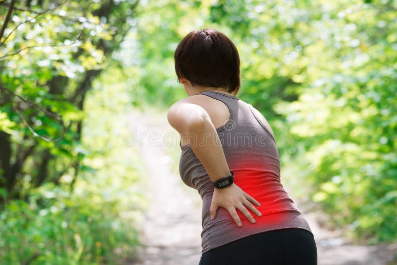 Woman with back pain, kidney inflammation, injury during workout, outdoors concept. Woman with back pain, kidney inflammation, injury during workout, outdoors concept