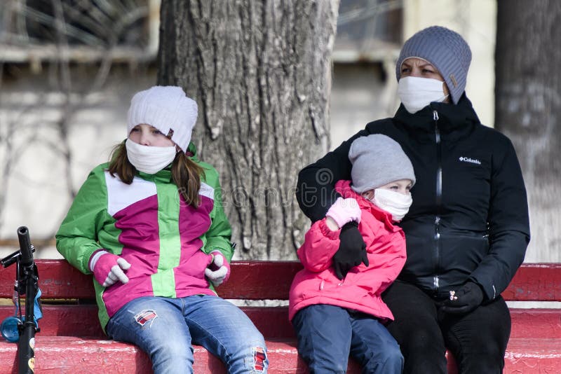 Kobieta z dziećmi nosząca maski ochronne przed koronavirus covid19 na ulicy w kijowskiej ukrainie w dniu 31 marca 2020 r.