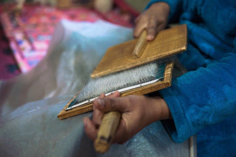 Kobieta z pÄ™dzlami przygotowujÄ…ca weÅ‚nÄ™ do wyprania weÅ‚ny na dywany berberyjskie