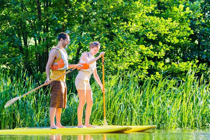 Kobieta z stoi up paddle deski sup na rzece fotografia stock Kobieta z stoi up paddle deski sup na rzece fotografia stock