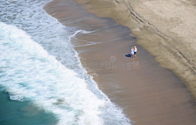 Kobiety chodzi na Dana pasemka plaży w Dana punkcie, Kalifornia obraz royalty free Kobiety chodzi na Dana pasemka plaży w Dana punkcie, Kalifornia obraz royalty free