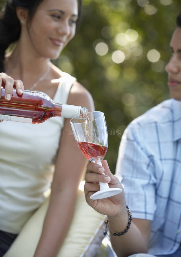 Kobiety dolewania wino W chłopaka szkło zdjęcie stock