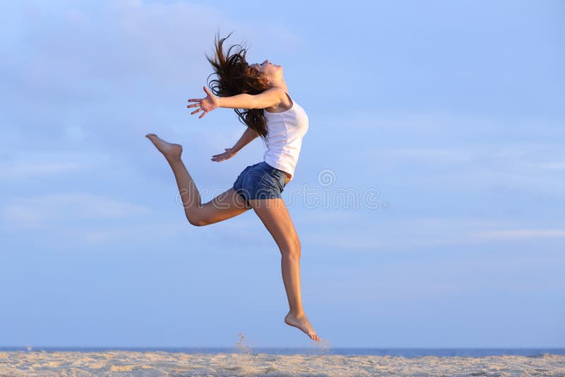 Woman jumping on the sand of the beach with the horizon in the background. Woman jumping on the sand of the beach with the horizon in the background