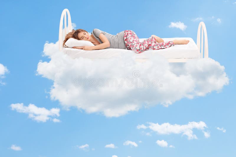 Kobiety dosypianie na wygodnym łóżku w chmurach