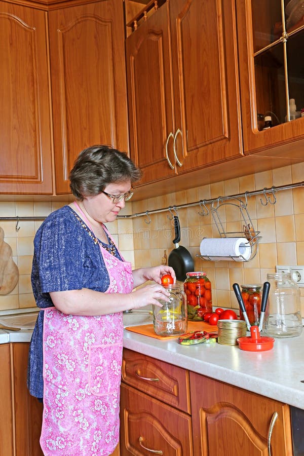 Kobiety gospodyni domowa angażująca w konserwuje warzywach