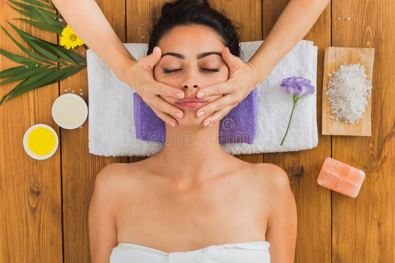Kobiety massagist robi twarz udźwigu masażowi w zdroju wellness centrum fotografia stock Kobiety massagist robi twarz udźwigu masażowi w zdroju wellness centrum fotografia stock