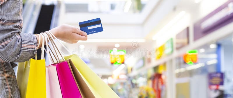 Kobiety mienia karta kredytowa I przewożenie Papierowe torby obraz royalty free Kobiety mienia karta kredytowa I przewożenie Papierowe torby obraz royalty free