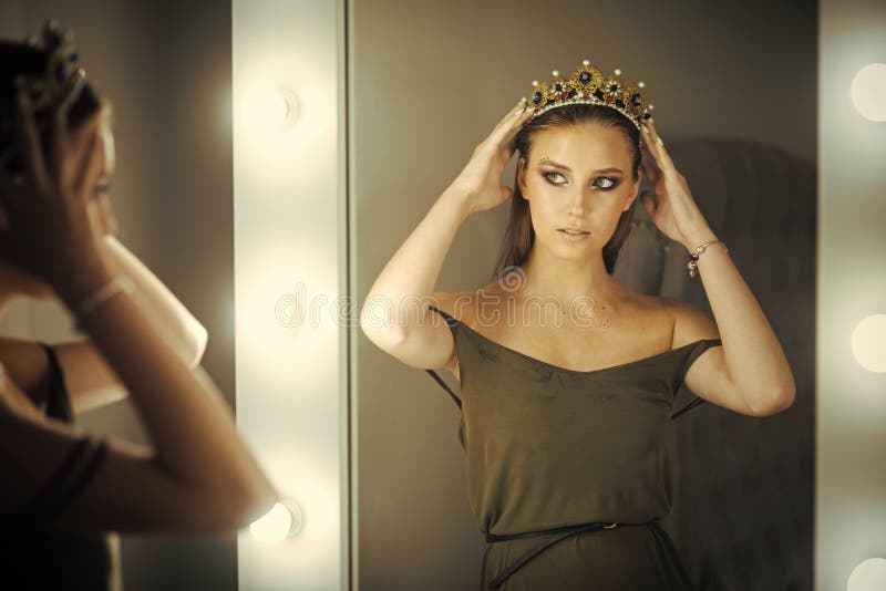 Kobiety odzieży biżuterii korona przy lustrem Piękno królowa z splendoru spojrzeniem w przebieralni Dziewczyny odbicie wewnątrz i