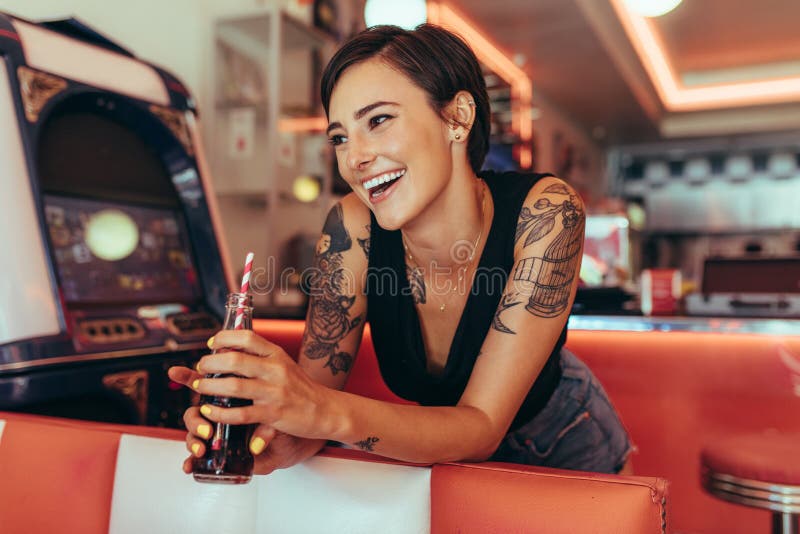 Kobiety pozycja obok hazard maszyny przy gościem restauracji trzyma miękką część obrazy stock Kobiety pozycja obok hazard maszyny przy gościem restauracji trzyma miękką część obrazy stock