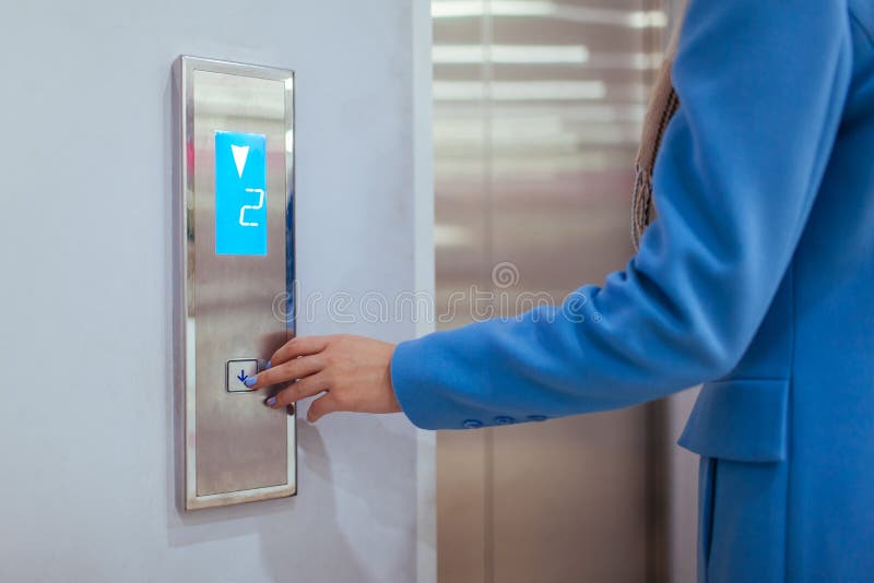 Kobiety pozycja W windzie I odciskanie Zapinamy w centrum handlowym zdjęcia stock Kobiety pozycja W windzie I odciskanie Zapinamy w centrum handlowym zdjęcia stock