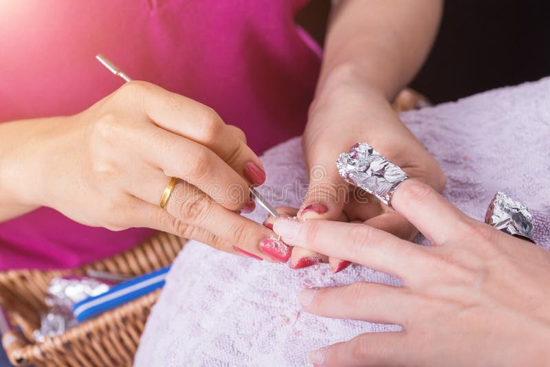 Kobiety ręka podczas gdy proces manicure w gwoździa sklepie Piękny przeciw zdjęcie stock Kobiety ręka podczas gdy proces manicure w gwoździa sklepie Piękny przeciw zdjęcie stock