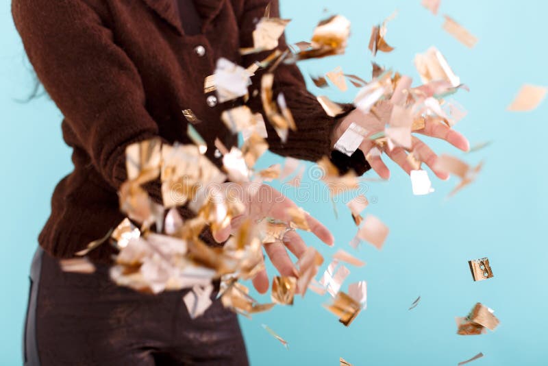 Kobiety ręka trzyma złotych confetti obrazy stock Kobiety ręka trzyma złotych confetti obrazy stock
