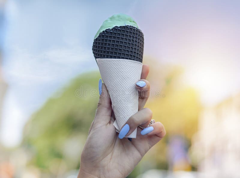 Kobiety ręki mienia lody gofra roztapiający rożek w rękach na letnim dniu obraz royalty free Kobiety ręki mienia lody gofra roztapiający rożek w rękach na letnim dniu obraz royalty free
