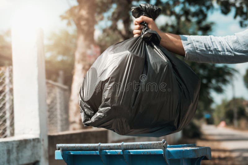 woman hand holding garbage black bag put in to trash. woman hand holding garbage black bag put in to trash