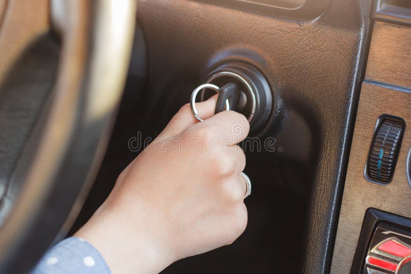 Kobiety ` s ręka na samochodowym ` s kluczu, próby zaczynać silnika, obraca dalej klucz w keyhole i toczy wewnątrz tło, auto ` s obrazy stock Kobiety ` s ręka na samochodowym ` s kluczu, próby zaczynać silnika, obraca dalej klucz w keyhole i toczy wewnątrz tło, auto ` s obrazy stock
