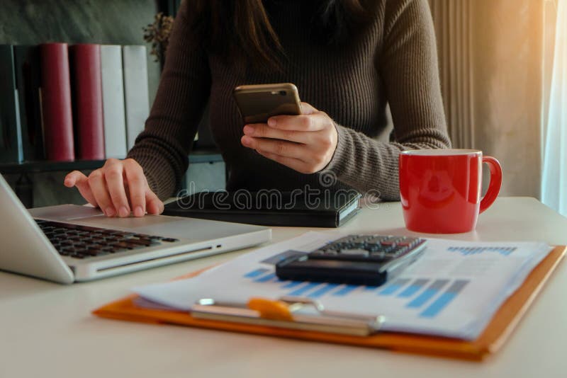 Kobiety używają smartphones i opodatkowywają kalkulatorów zdjęcia stock Kobiety używają smartphones i opodatkowywają kalkulatorów zdjęcia stock