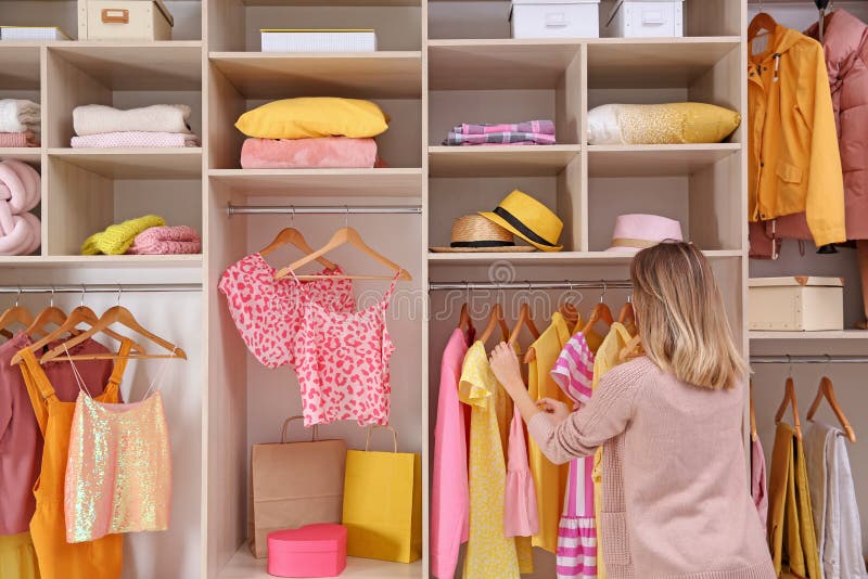 Woman choosing clothes from large wardrobe closet. Woman choosing clothes from large wardrobe closet