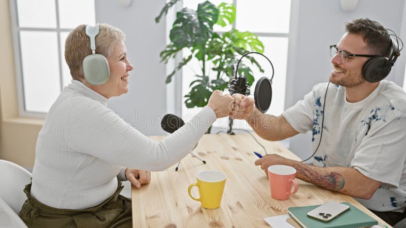 Kobietę i mężczyznę z uśmiechem w studio podcast wnętrze z mikrofonami i słuchawkami obraz royalty free