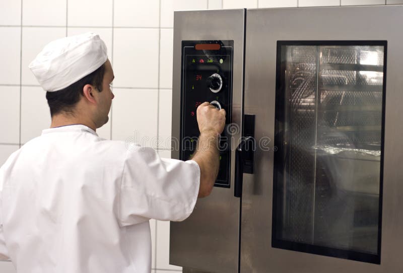 A professional stove (oven) used in a commercial kitchen for preparing large amounts of food. The cook operating the machine. A professional stove (oven) used in a commercial kitchen for preparing large amounts of food. The cook operating the machine.