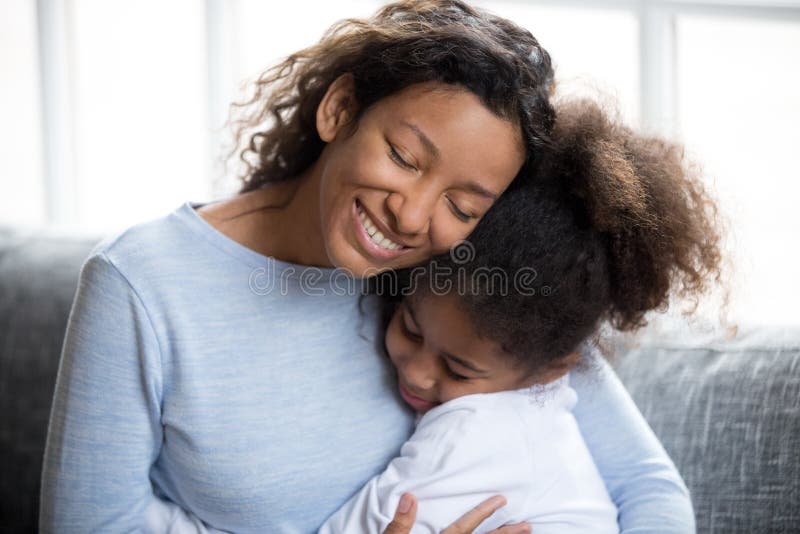 Kochający amerykanin afrykańskiego pochodzenia matki obejmowanie z córką