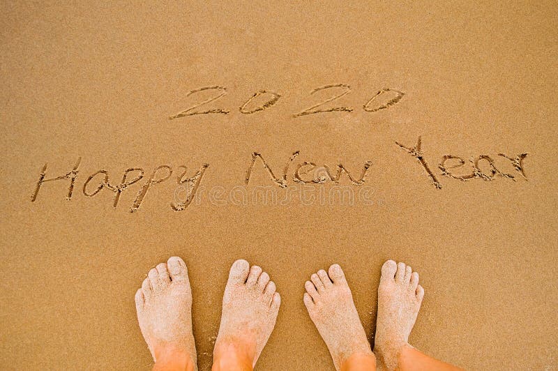 Kochanek Pisze 2020 szczęśliwych nowy rok na plaży zdjęcie stock Kochanek Pisze 2020 szczęśliwych nowy rok na plaży zdjęcie stock