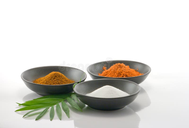 Cooking spices in black bowls on white background with leaf. Cooking spices in black bowls on white background with leaf