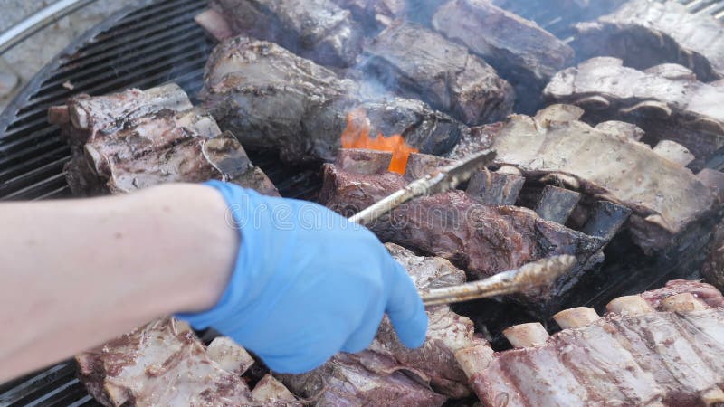 Kochen großer saftiger Stücke von rohem, fettem, mariniertem Schweinefleisch Rindfleischkälber auf einer Wiege Amerikanischer Gri