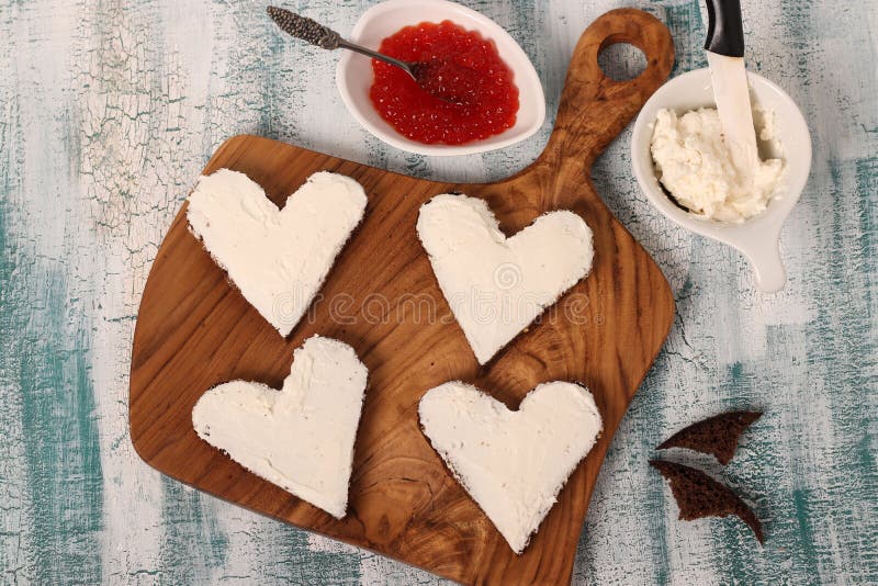 Kochen von Sandwichen mit rotem Kaviar- und Frischkäse in Form eines Herzens für Valentinstag lizenzfreies stockfoto Kochen von Sandwichen mit rotem Kaviar- und Frischkäse in Form eines Herzens für Valentinstag lizenzfreies stockfoto