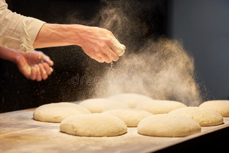 Food cooking, baking and people concept - chef or baker making dough at bakery. Food cooking, baking and people concept - chef or baker making dough at bakery