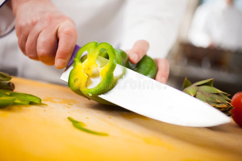 Kock som klipper en paprika royaltyfri fotografi