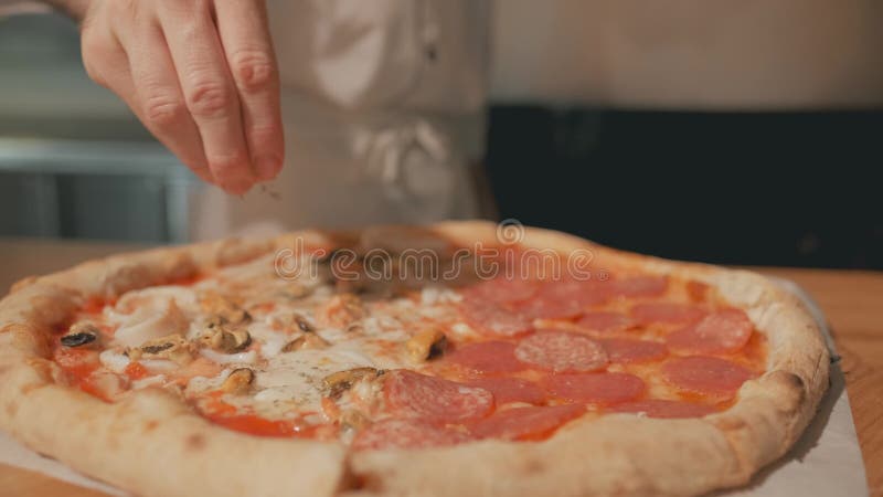 Kockhänder strilar pizza med jordpeppar eller kryddor längd i fot räknat för närbild 4k