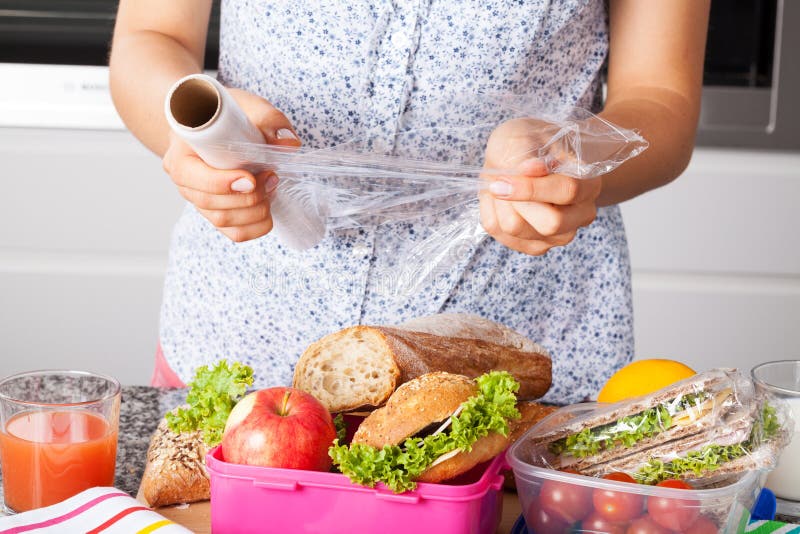 Woman packing food for lunch in plastic and boxes. Woman packing food for lunch in plastic and boxes