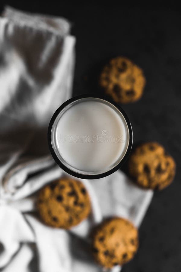 Koekjes met chocoladeschepen en melk met een donkere achtergrond royalty-vrije stock afbeeldingen Koekjes met chocoladeschepen en melk met een donkere achtergrond royalty-vrije stock afbeeldingen