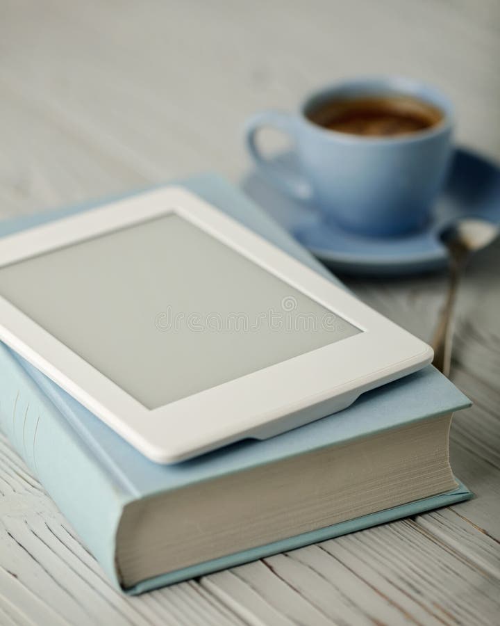 Koffie in een lichtblauwe kop en boek in een blauwe dekking met een elec stock foto's Koffie in een lichtblauwe kop en boek in een blauwe dekking met een elec stock foto's