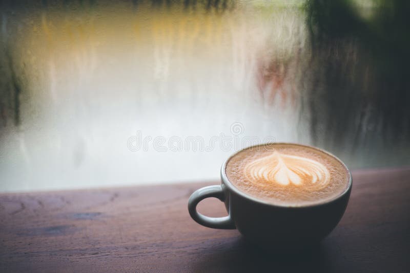 Koffie latte op houten lijst, die buiten regenen royalty-vrije stock foto Koffie latte op houten lijst, die buiten regenen royalty-vrije stock foto