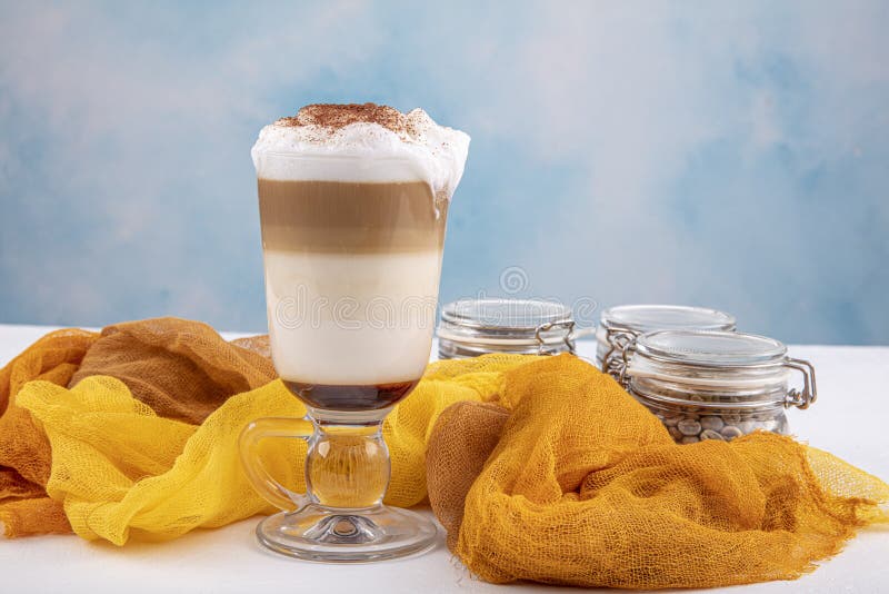 Koffiecafé latte macchiato in een hoog glas op een houten achtergrond Er is kopieerruimte naast het glas stock afbeelding Koffiecafé latte macchiato in een hoog glas op een houten achtergrond Er is kopieerruimte naast het glas stock afbeelding