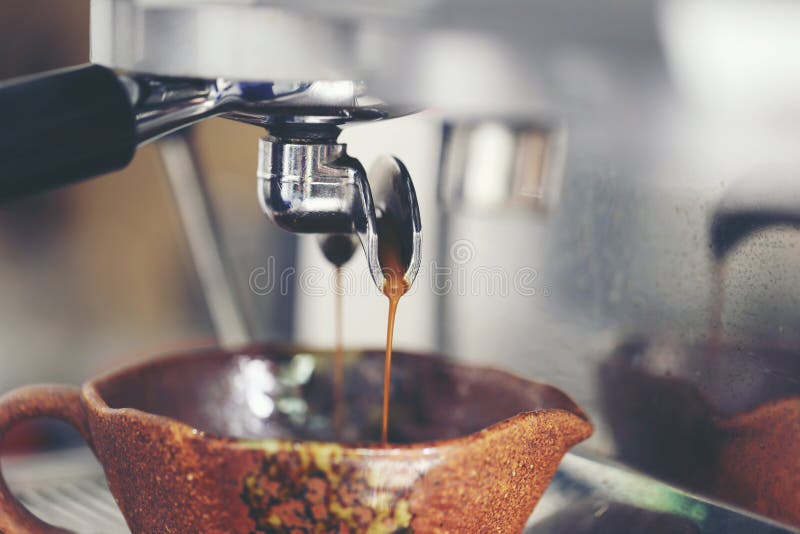 Koffieextractie het gieten in een kop van professionele koffiemachine met bar binnenlandse achtergrond
