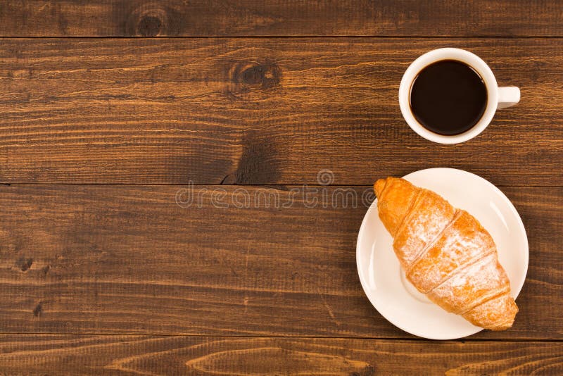 Koffiekop met croissant voor ontbijt op een donkere houten lijst, hoogste mening stock fotografie Koffiekop met croissant voor ontbijt op een donkere houten lijst, hoogste mening stock fotografie