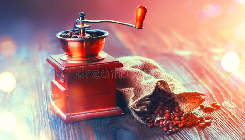 Koffiemolen en Geroosterde Koffiebonen Koffiemolen met het hoogtepunt van de jutezak van geroosterde bonen over houten lijst royalty-vrije stock afbeelding Koffiemolen en Geroosterde Koffiebonen Koffiemolen met het hoogtepunt van de jutezak van geroosterde bonen over houten lijst royalty-vrije stock afbeelding