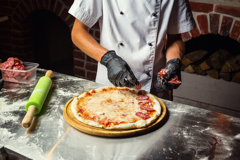 Kok Chef die heerlijke pizza bij het restaurant, close-up maken royalty-vrije stock fotografie Kok Chef die heerlijke pizza bij het restaurant, close-up maken royalty-vrije stock fotografie