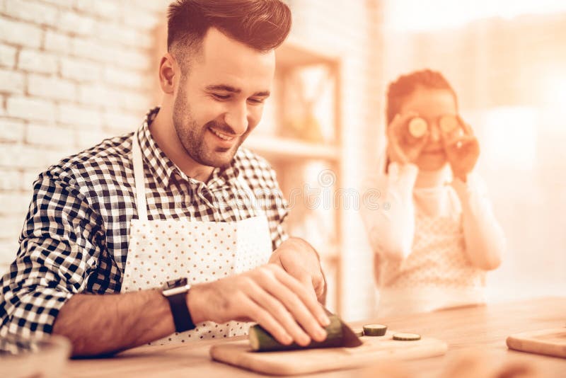 Kok Food thuis Gelukkige Familie De dag van de vader `s Meisje en Mens Cook Food Mens en Kind bij Lijst Breng samen tijd door ges royalty-vrije stock foto Kok Food thuis Gelukkige Familie De dag van de vader `s Meisje en Mens Cook Food Mens en Kind bij Lijst Breng samen tijd door ges royalty-vrije stock foto