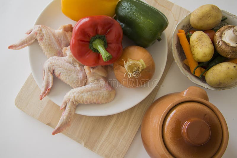 Kokende ingrediënten: kippenvleugels en plantaardige hutspot stock afbeelding Kokende ingrediënten: kippenvleugels en plantaardige hutspot stock afbeelding