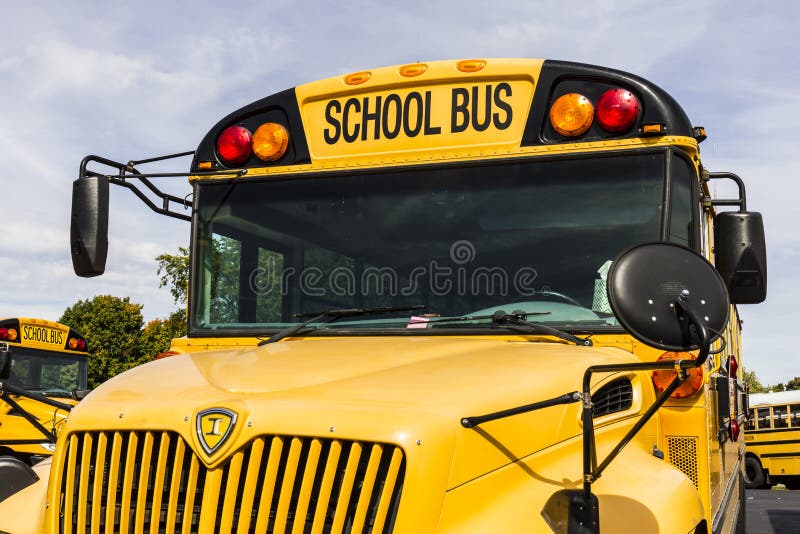 Kokomo - vers en octobre 2016 : Autobus scolaires jaunes dans un sort de secteur attendant pour partir pour des étudiants IV photos stock Kokomo - vers en octobre 2016 : Autobus scolaires jaunes dans un sort de secteur attendant pour partir pour des étudiants IV photos stock