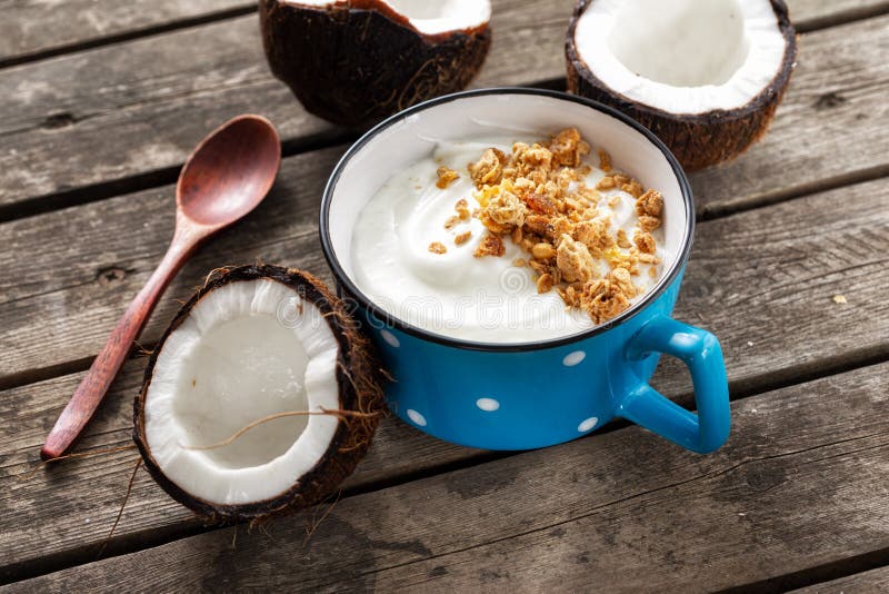 Kokosyoghurt med granola i kopp på träbord Probiotiska livsmedel Tasty och hälsosam frukost royaltyfri bild