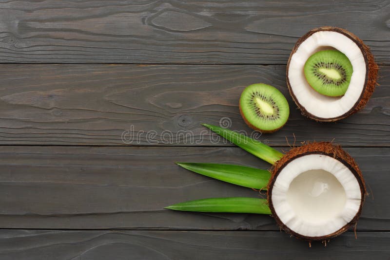 Koks z kiwi zielenią i owoc opuszcza na ciemnym drewnianym tle Odgórny widok z kopii przestrzenią fotografia stock Koks z kiwi zielenią i owoc opuszcza na ciemnym drewnianym tle Odgórny widok z kopii przestrzenią fotografia stock