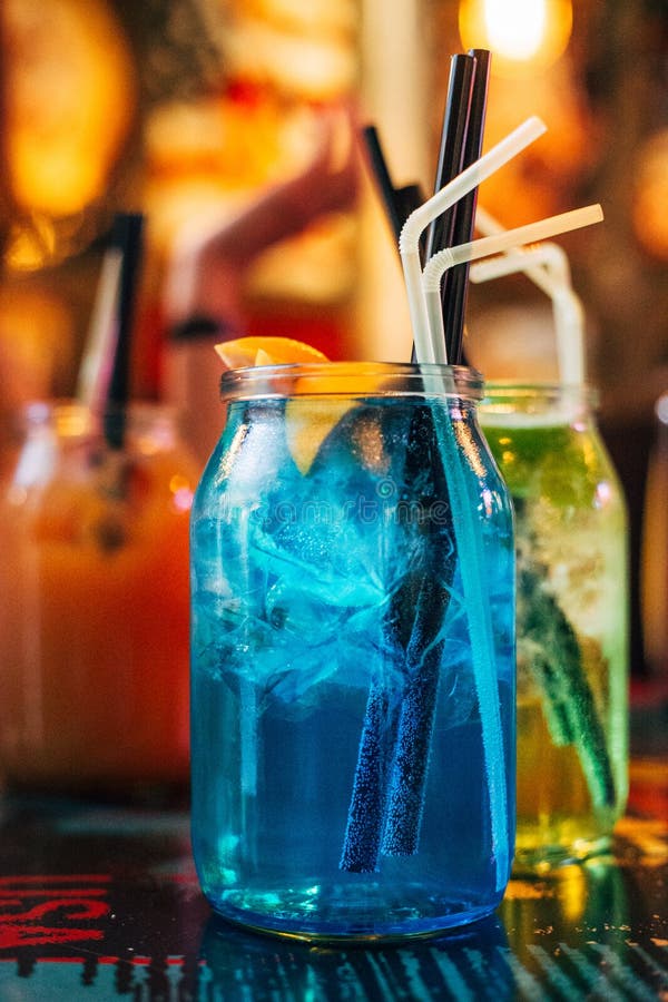 Koktajle letnie w Big Jars Mojito, Blue Lagoon i Peach Cocktail obraz royalty free Koktajle letnie w Big Jars Mojito, Blue Lagoon i Peach Cocktail obraz royalty free