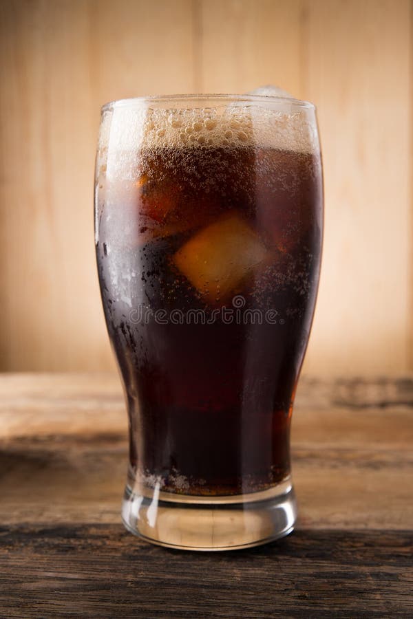 Cold fizzy cola soda with ice in glass cup. Cold fizzy cola soda with ice in glass cup