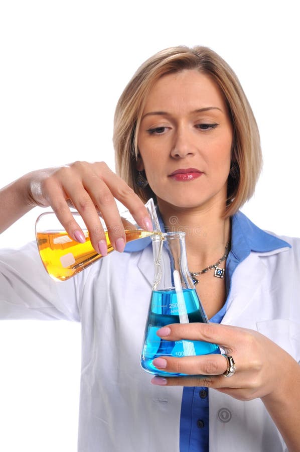 Lab tech mixing liquids from two flasks. Lab tech mixing liquids from two flasks